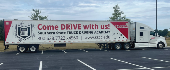 A semi truck with a sign that says come drive with us.